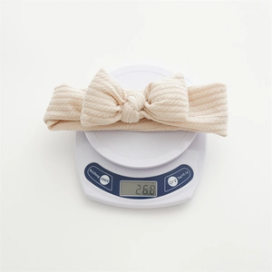 Gros plan d'un bandeau à nœud côtelé beige pesant 26,8g sur une balance