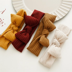 Détail de quatre bandeaux bébé en maille côtelée avec nœuds aux couleurs vives