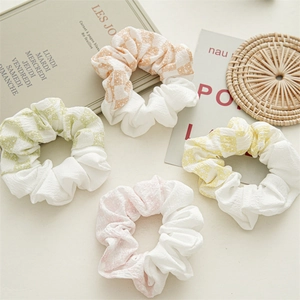 Détail d'un ensemble de quatre chouchous aux motifs floraux à carreaux pastel doux