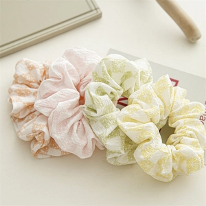 Vue détaillée de quatre chouchous en tissu à fleurs et carreaux aux tons pastels