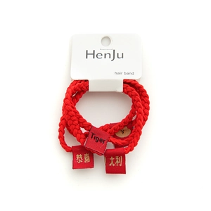 Three-piece red woven hair rings with festive gold text labels on white packaging