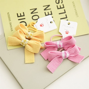 Close-up of cute bow hair ties for girls in mustard yellow and cherry blossom pink