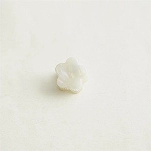 Détail macro d'une mini pince à cheveux fleur en acétate avec texture nacrée