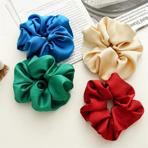 Set of four glossy satin scrunchies in royal blue, champagne, emerald green, and red silk fabric