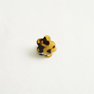 Détail d'une mini pince à cheveux en forme de fleur avec motif écailles de tortue en acétate