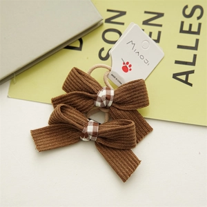 Detail of coffee brown bow hair ties with black and white plaid center on card