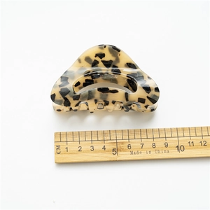 Acetate hair claw clip with tortoise shell leopard print in a triangular cutout design