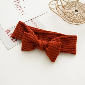 Détails de la maille côtelée du bandeau orange pour bébé avec un joli nœud décoratif