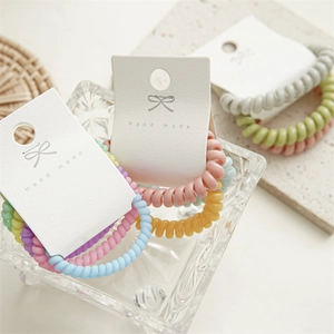 Détail de chouchous spirales colorés présentés sur des cartes faites à la main