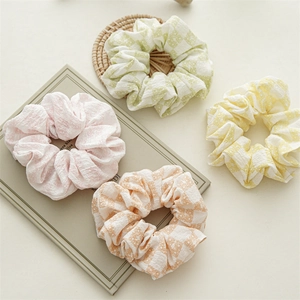 Vue détaillée de quatre chouchous colorés en seersucker avec des motifs de marguerites