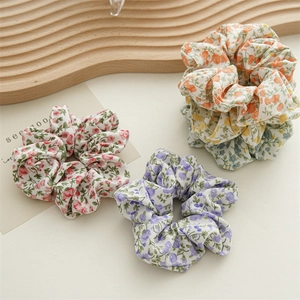 Set di elastici per capelli in chiffon a fiori pastello su un vassoio di legno