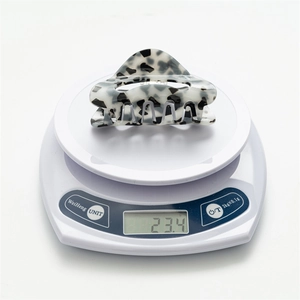 Detailed view showing the square leopard print hair claw clip being weighed at 23.4g