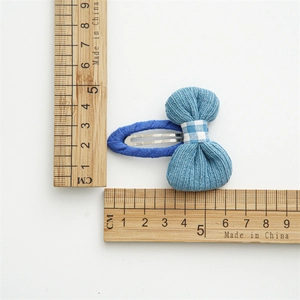 Detailed size measurement of a 5.5cm blue knitted bow hair clip with a silver metal base