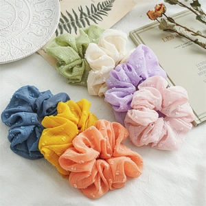 Set of seven pastel seersucker scrunchies in candy colors on a vintage aesthetic background