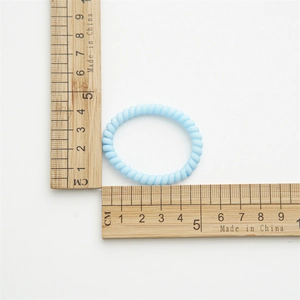 Mesure détaillée d'un élastique spirale bleu clair montrant son diamètre de 4 cm