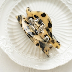 Detail shot of leopard print acrylic hair claw clip with golden metal spring mechanism