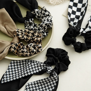 Elegant houndstooth and solid color scrunchies with long ribbon bows for hair styling