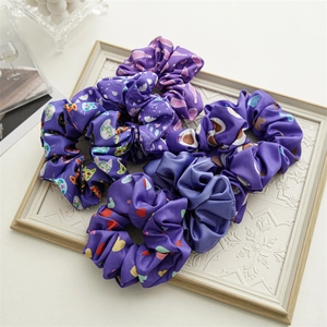 Detail view of periwinkle blue and purple satin scrunchies in a vintage white frame