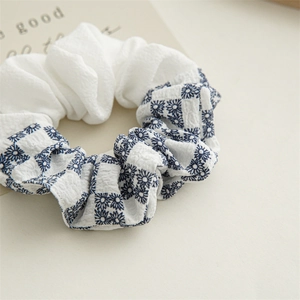 Blue and white checkered daisy pattern hair scrunchie with pleated white fabric detail