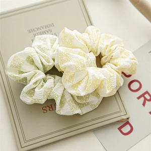 Détail de chouchous à fleurs jaunes et verts avec texture plissée sur livre