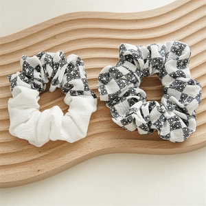 Floral and white patchwork scrunchies on a wooden board for casual spring hairstyles