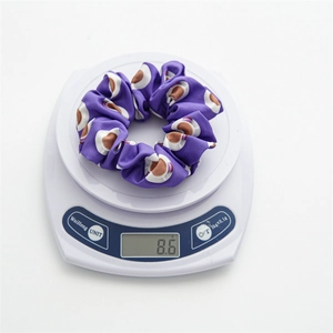 Detailed view of periwinkle floral scrunchie on electronic scale showing 8.6g weight