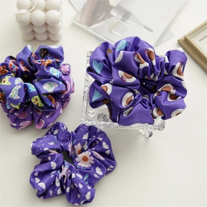 Three-piece purple floral satin scrunchies featuring cat, heart, and daisy patterns