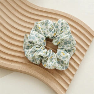 Dettaglio dell'elastico in chiffon floreale con motivo blu su vassoio in legno