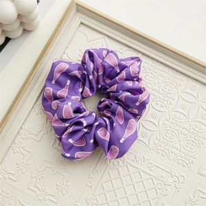 Detailed close-up of periwinkle blue satin scrunchie with pink floral patterns