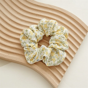 Dettaglio della fantasia floreale gialla sull'elastico in chiffon per lo styling dei capelli