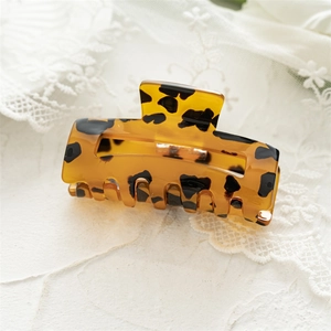 Macro detail of tortoiseshell leopard print hair claw clip made of polished acetate