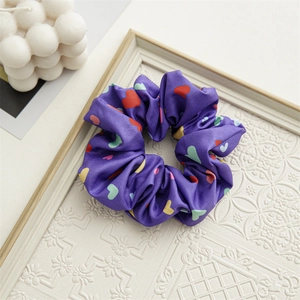 Detail view of purple satin scrunchie with colorful heart patterns on a vintage frame
