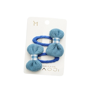 Pair of blue bow BB hair clips with ribbed texture on handmade display card