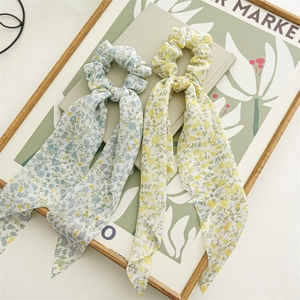 Detail von floralen Chiffon-Haargummis mit langen Bändern in Blau und Gelb Mustern