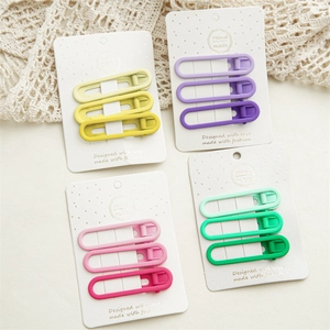 Close-up of matte candy-colored hair clips set on cards with handmade details