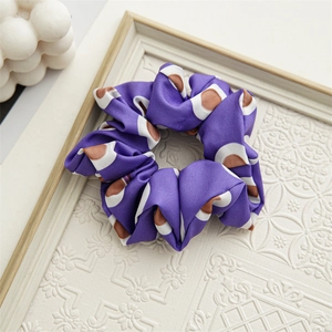 Detailed view of periwinkle blue satin scrunchie with geometric patterns and soft texture