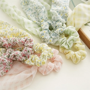 Detailaufnahme von Scrunchies mit Blumenmuster und Karos sowie langen Haarbändern