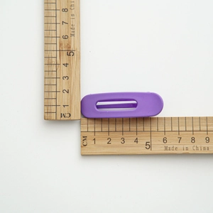 Gros plan d'une pince à cheveux violette mate avec mesures de taille en centimètres