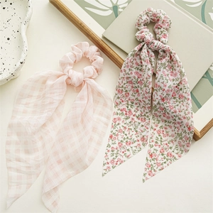 Haargummis mit rosa Karomuster und floralem Print mit langen Bändern auf hellem Grund