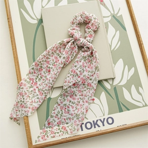 Detailansicht eines Chiffon-Haargummis mit Blumenmuster und langen Bändern für Damen
