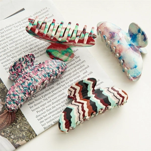 Set of four large acetate hair claws with colorful floral and marble patterns for women