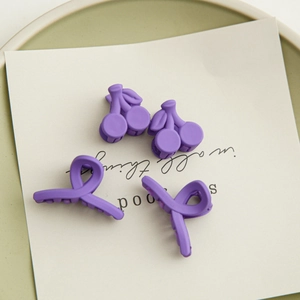 Vue détaillée de quatre pinces à cheveux mates violettes, motifs cerises et géométriques