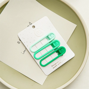 Three gradient green matte metal hair clips set on white card with a spring clip design