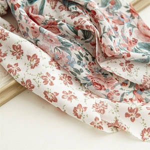 Floral chiffon hair ribbon with pink flowers and green leaves on cream fabric background