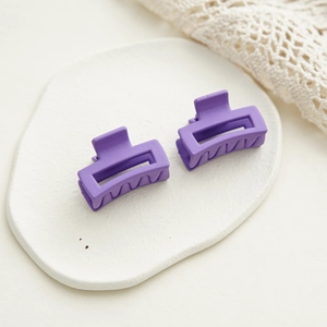 Détail de mini pinces à cheveux mates violettes sur un plateau décoratif de coiffure