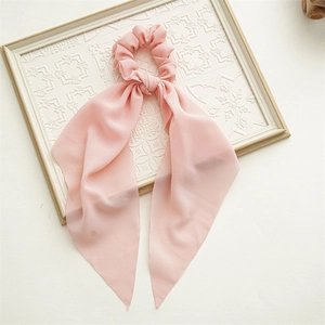 Close-up of pink floral chiffon hair scrunchie with long ribbon on vintage frame