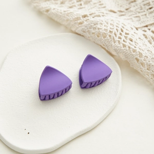 Vue détaillée de deux pinces à cheveux triangulaires violettes mates sur plat