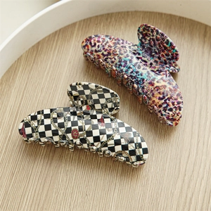 Close-up of large acetate hair claws in colorful leopard and checkerboard patterns