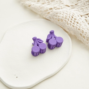 Détail de pinces à cheveux cerise violet mat sur plaque en plâtre avec dentelle