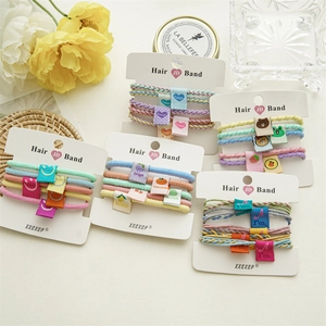 Macro detail of colorful elastic hair bands with cute fruit and smiley face fabric tags